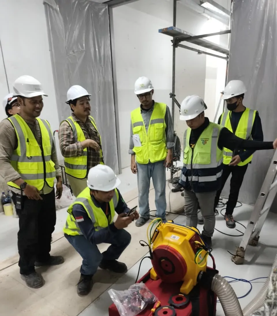The Pariksa team around the yellow test fan, reading results during a duct leakage test.